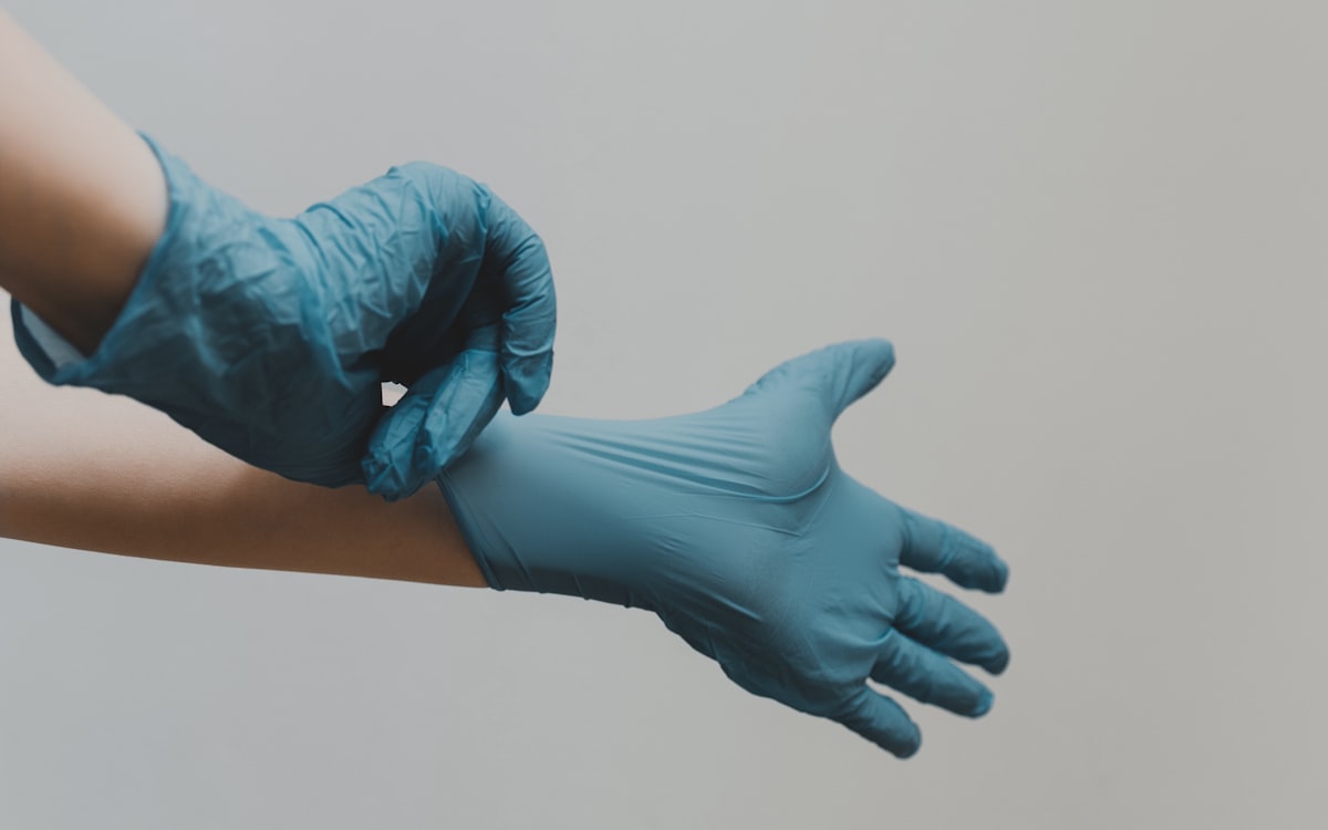 Technician pulling on protective gloves before remediation work